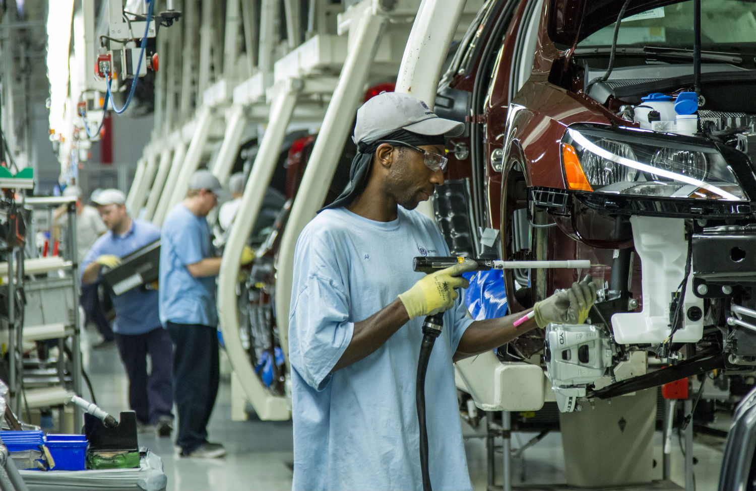 Karoseria VW Passat przejeżdża przez kabinę lakierniczą z natryskiem farby