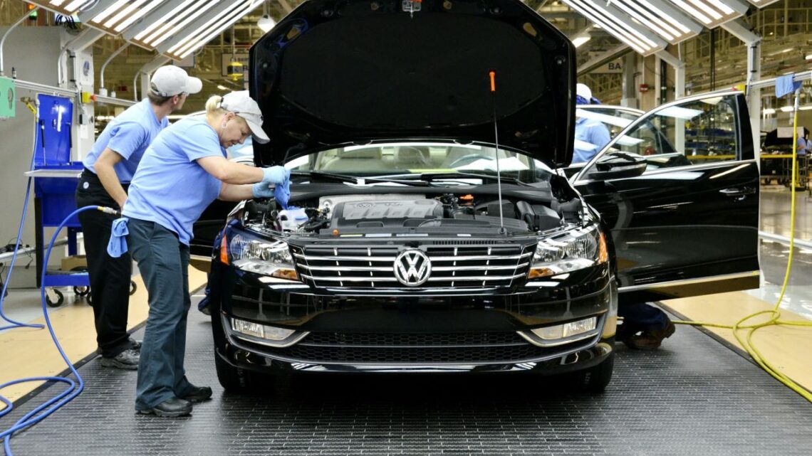 Nowoczesna linia produkcyjna VW Passat z robotami i pracownikami w fabryce Volkswagen