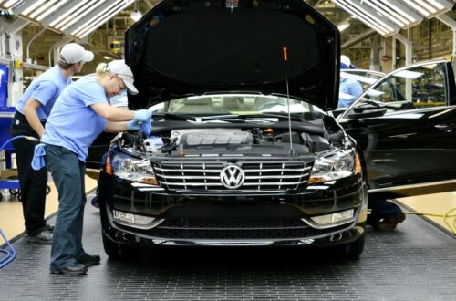 Nowoczesna linia produkcyjna VW Passat z robotami i pracownikami w fabryce Volkswagen