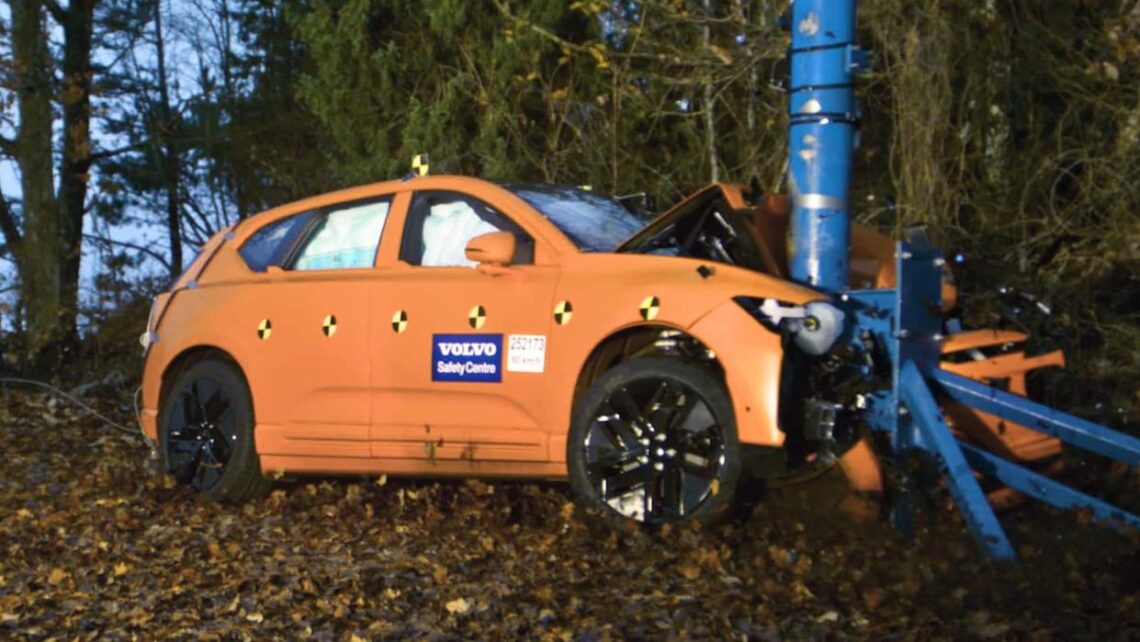 Czerwony Volkswagen Golf uderza frontalnie w sztywną barierę podczas crash testu w laboratorium
