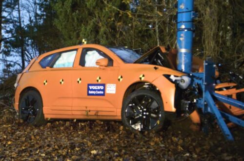 Czerwony Volkswagen Golf uderza frontalnie w sztywną barierę podczas crash testu w laboratorium